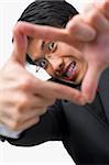 Portrait of Asian businessman looking at his perspective by framing his fingers to the camera
