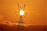Pylônes électriques au coucher du soleil orange