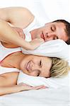 Couple in bed. Woman trying to sleep while a man is snoring