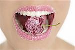 Cherry with sugar lips between woman perfect teeth macro mouth