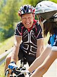 Senior man and young woman on road bike