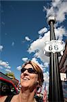 Woman on side of route in front of Route 66 sign