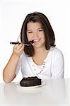 Cute Caucasian child eating a slice of chocolate cake