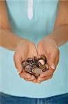 Femmes mains tenant une main pleine de pièces de monnaie