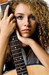 An attractive young teenage woman with an acoustic guitar on white background