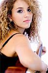 An attractive young teenage woman with an acoustic guitar on white background (shallow depth of field used)