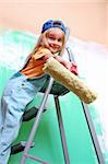 smiling little girl on a ladder with a roller