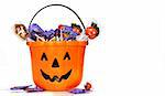 Jack-o-Lantern bucket filled with candies on white background