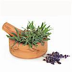 Lavender herb leaves in an olive wood mortar with pestle, with dried flowers,  over white background.