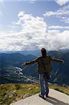 Young man standing on the top of a mountain