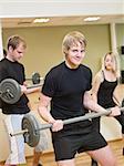 Group of people lifting weights with a young man in focus