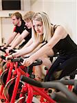 Group of people having spinning class with a girl in focus