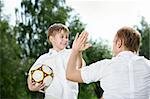Small son - the football player welcomes the father, summer