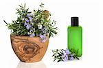 Rosemary and thyme herb leaves and flowers in an olive wood mortar with pestle with an aromatherapy bottle and floral leaf sprig, over white background.