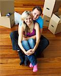 High angle of a couple sitting on floor together. Moving house