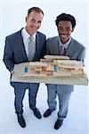 Happy architects holding a model house