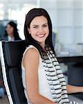 Smiling brunette businesswoman sitting in her workplace