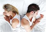 Sad and angry couple lying in bed separately after having an argument. Marriage trouble