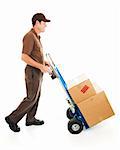 Full body side view of a delivery man or mover carrying boxes on a hand truck.  Isolated