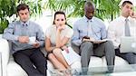 Bored multi-ethnic business people sitting on a sofa waiting for an interview