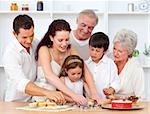 Happy parents, grandparents and children baking in the kitchen