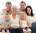 Portrait of family watching television and eating chips at home