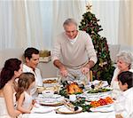 Family having Christmas dinner eating turkey at home