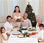 Family celebrating Christmas dinner with turkey at home