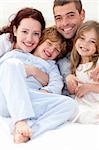 Portrait of young family lying together in bed