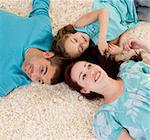 Happy young family on floor with heads together