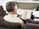 senior man reading book at home