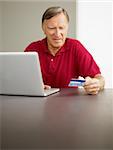 senior man with laptop computer and credit card. Copy space