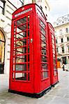 Two red telephone boxes near on London sidewalk