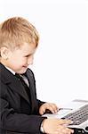 Little boy in a business suit with the laptop