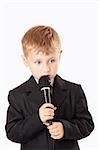 Little boy sings something with a microphone in a hand, isolated