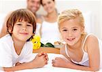 Portrait of children in bed with their parents after having breakfast