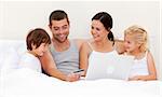 Family buying online with a laptop in bed