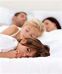 Little boy relaxing with his parents and sister sleeping