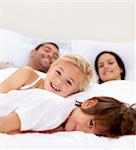 Young family relaxing together in parent's bed