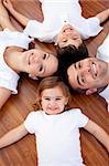 High angle of happy family lying on floor with heads together