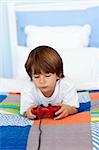 Little boy playing videogames in his bedroom
