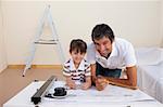 Father and son drawing architectural plans at home