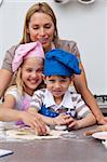 Mother helping her children baking in the kitchen