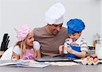 Smiling father and children baking in the kitchen