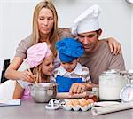 Children baking cookies with their parents in the kitchen