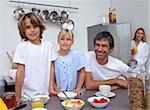 Smiling family preparing breakfast in the kitchen