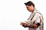 Side view of young  jewish man with book on white isolated background