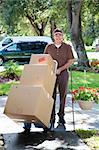 Delivery man or mover bringing boxes up your front walk.