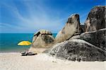 two sun loungers under yellow umbrella on white sand beach of koh samui thailand