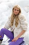 Snow, water, ice and beautiful blond girl in winter clothes